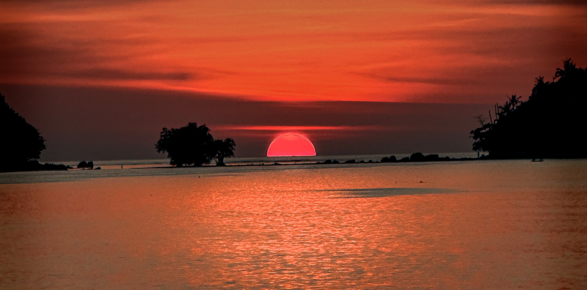 Sunset Ritual — silhouettes performing a traditional ritual against a blazing sunset sky